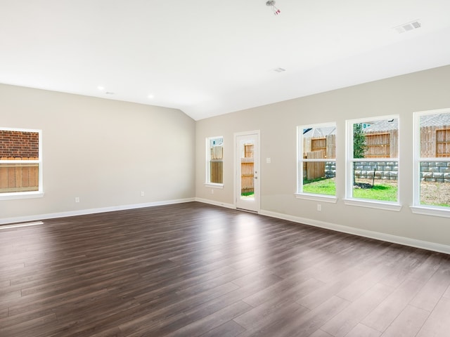 unfurnished living room with lofted ceiling, dark wood-style floors, and baseboards