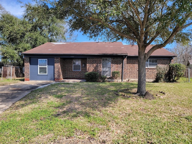 ranch-style home featuring brick siding, a front yard, and fence