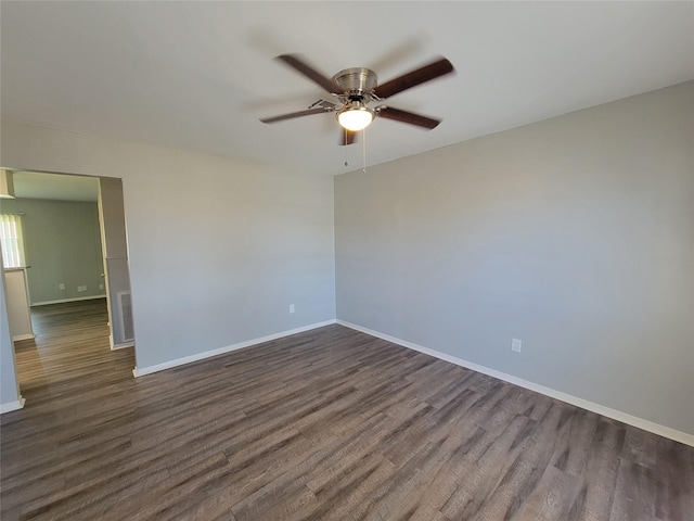 empty room with dark wood-style floors, ceiling fan, visible vents, and baseboards