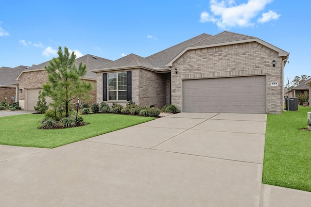 view of front of property with driveway, roof with shingles, an attached garage, a front lawn, and brick siding