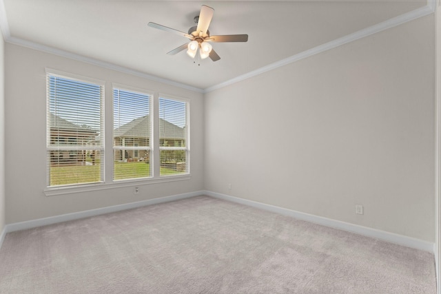 spare room with light colored carpet, crown molding, and baseboards