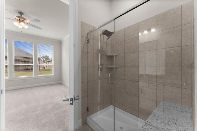 bathroom with baseboards, ceiling fan, a shower stall, and crown molding