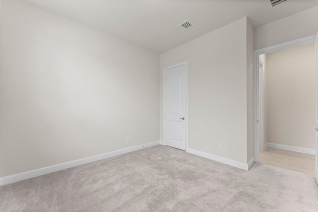 unfurnished bedroom featuring baseboards, visible vents, and light colored carpet