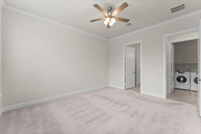 unfurnished bedroom featuring light carpet, visible vents, baseboards, ornamental molding, and independent washer and dryer