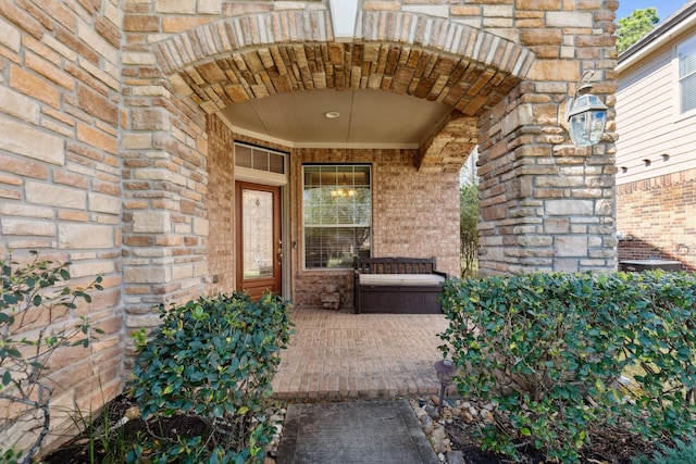 entrance to property featuring stone siding and brick siding