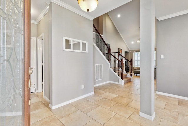 foyer entrance with visible vents, baseboards, stairs, a towering ceiling, and crown molding