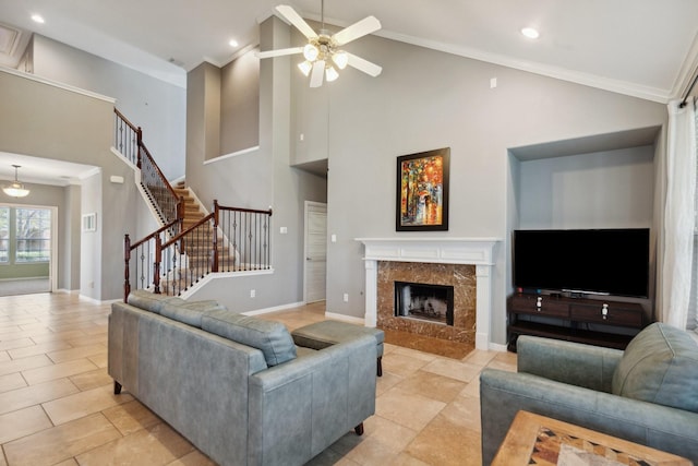 living area featuring crown molding, recessed lighting, a premium fireplace, baseboards, and stairs