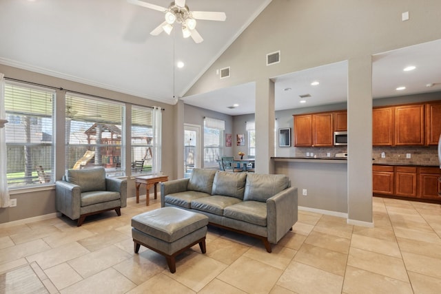 living room with ornamental molding, visible vents, and baseboards