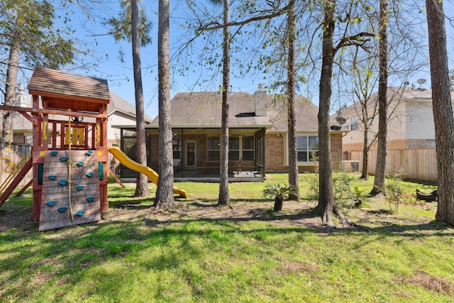 view of play area featuring a yard, fence, and a sunroom