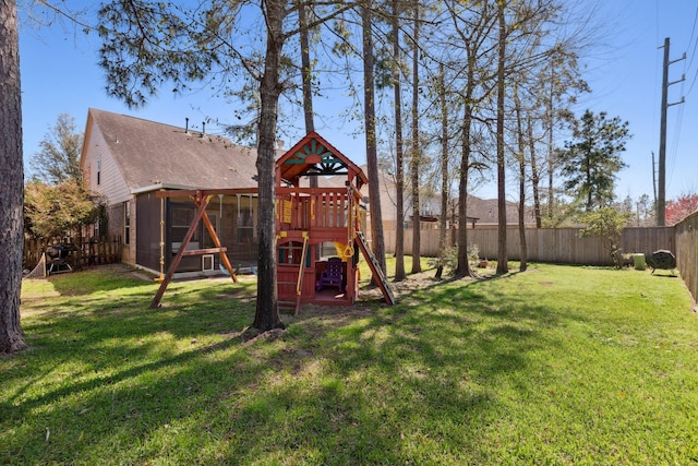 view of yard with a sunroom, a fenced backyard, and a playground