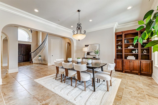 dining room with ornamental molding, arched walkways, baseboards, and recessed lighting