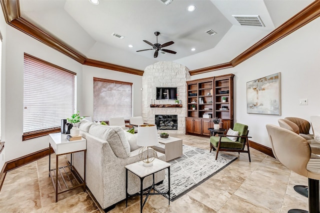 living area featuring a fireplace, a raised ceiling, visible vents, and crown molding