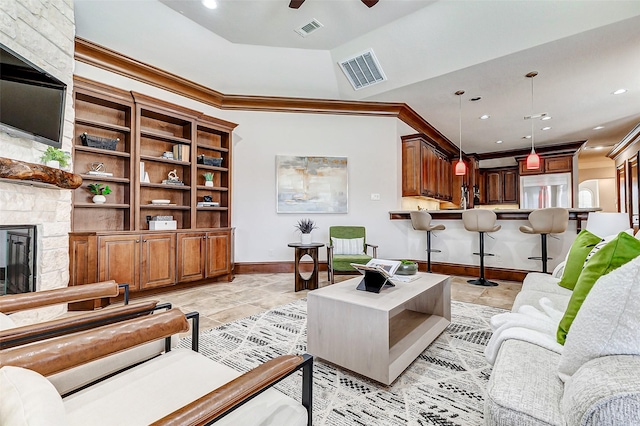 living room with ornamental molding, visible vents, a fireplace, and baseboards