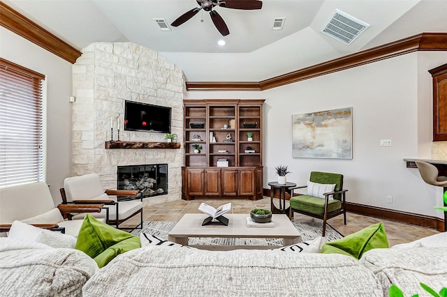 living area featuring ornamental molding, a stone fireplace, vaulted ceiling, and visible vents