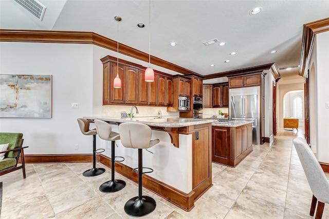 kitchen with built in appliances, a peninsula, arched walkways, and visible vents