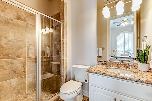 bathroom featuring ceiling fan, a shower stall, toilet, and vanity