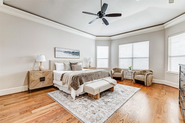 bedroom with ornamental molding, light wood-style flooring, and baseboards