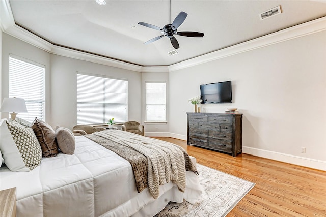 bedroom featuring ornamental molding, light wood-type flooring, visible vents, and baseboards