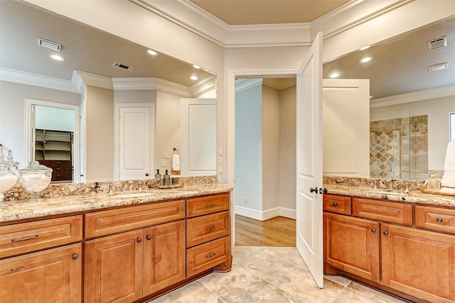 bathroom with a stall shower, visible vents, and a sink