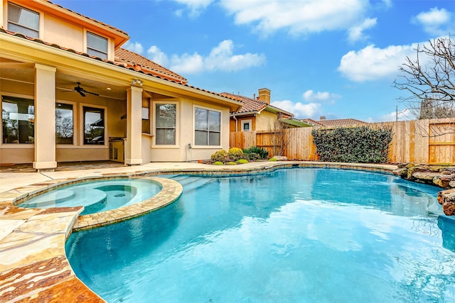 view of pool with a patio area, a fenced backyard, a pool with connected hot tub, and a ceiling fan