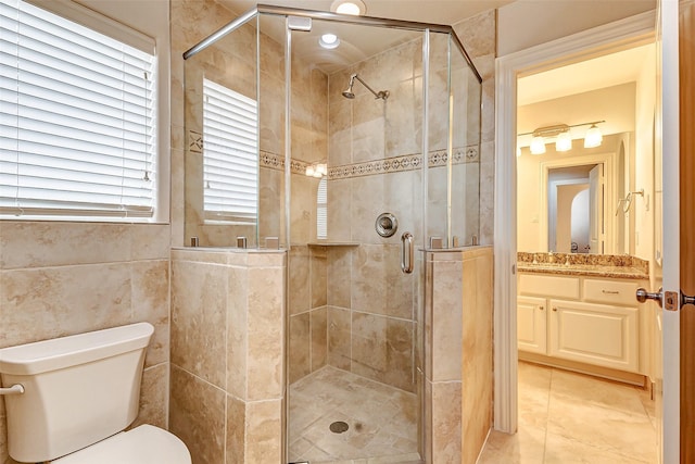 bathroom featuring vanity, a shower stall, and toilet