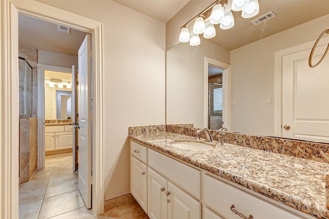 bathroom with a shower stall, visible vents, tile patterned flooring, and vanity