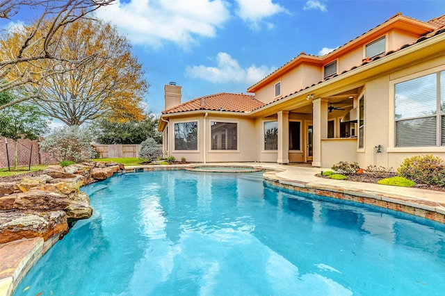 view of swimming pool with ceiling fan, an in ground hot tub, fence, a fenced in pool, and a patio area