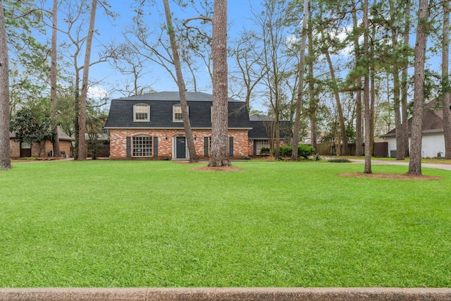 exterior space featuring roof with shingles, brick siding, and a front lawn