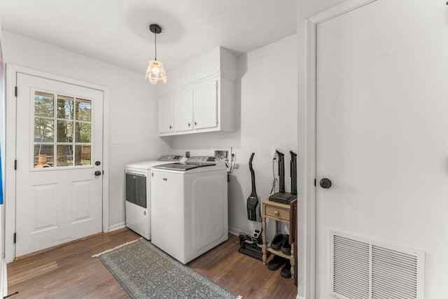 laundry room featuring washing machine and clothes dryer, cabinet space, visible vents, light wood-style flooring, and baseboards