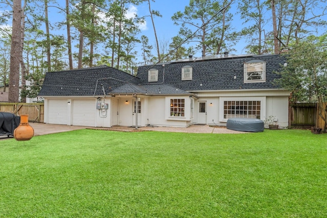 rear view of property with mansard roof, an attached garage, fence, concrete driveway, and roof with shingles