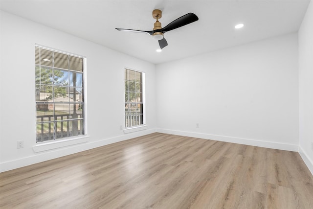 spare room featuring plenty of natural light, light wood-style flooring, and baseboards