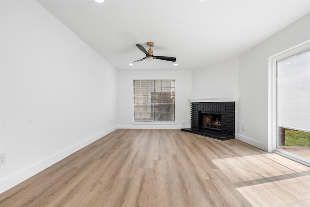 unfurnished living room with a fireplace, recessed lighting, a ceiling fan, light wood-type flooring, and baseboards