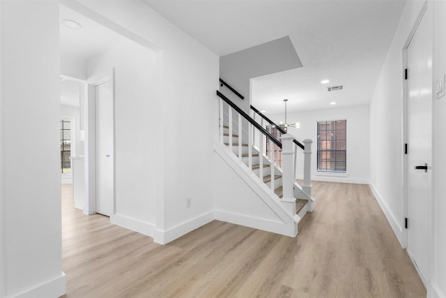 staircase with a chandelier, recessed lighting, wood finished floors, visible vents, and baseboards