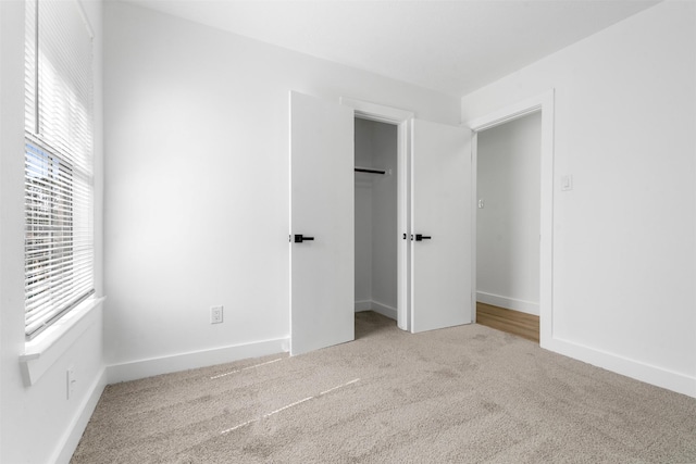 unfurnished bedroom featuring carpet floors, a closet, and baseboards