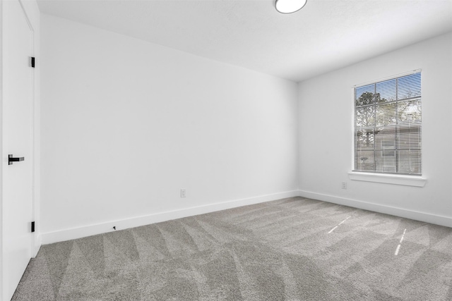 unfurnished room featuring carpet floors and baseboards