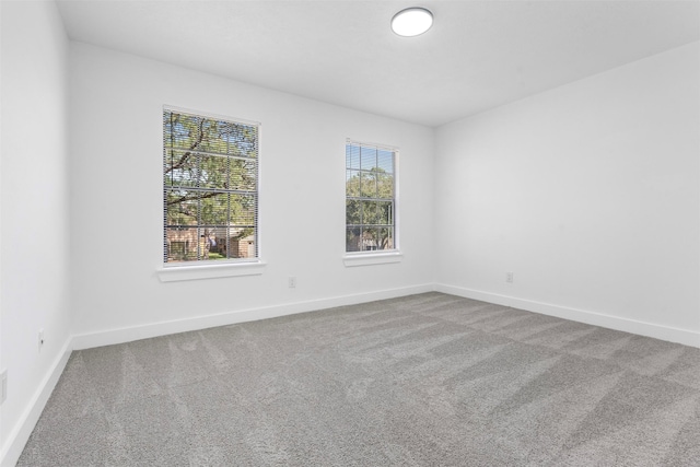 unfurnished room featuring carpet and baseboards