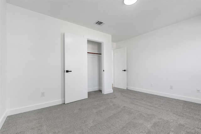 unfurnished bedroom with carpet, a closet, visible vents, and baseboards