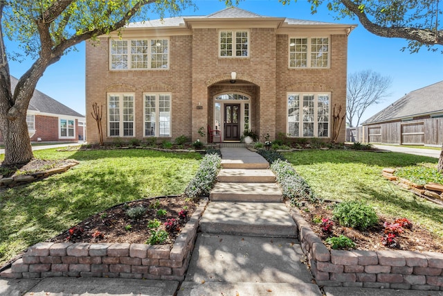 view of front facade featuring a front yard and brick siding