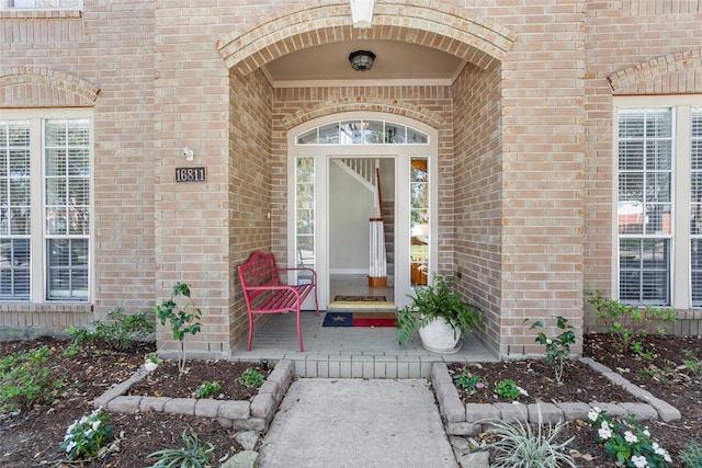 doorway to property featuring brick siding