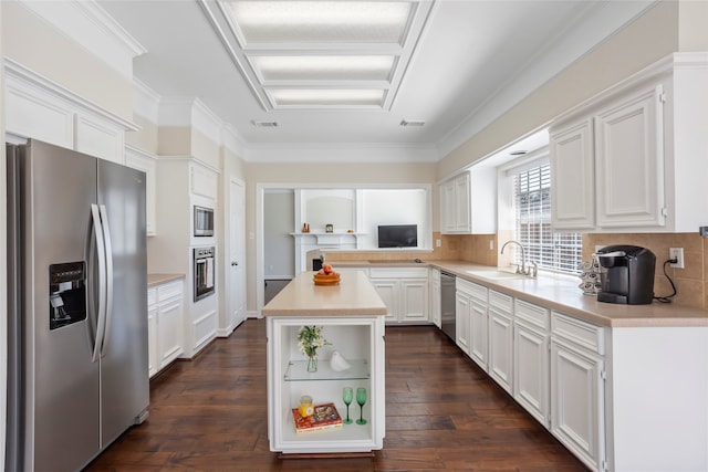 kitchen featuring a sink, white cabinets, appliances with stainless steel finishes, backsplash, and dark wood-style floors