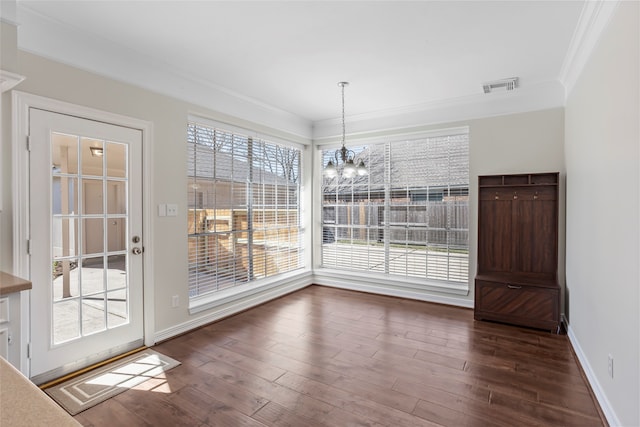 unfurnished dining area featuring ornamental molding, dark wood-style flooring, visible vents, and plenty of natural light