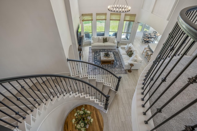 stairway featuring wood finish floors and a notable chandelier