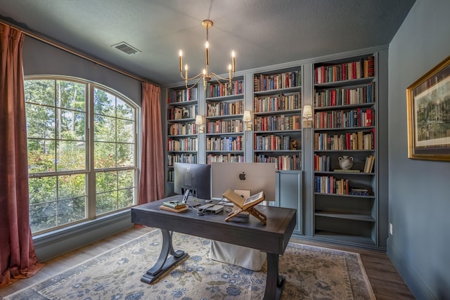 home office with baseboards, visible vents, wood finished floors, a textured ceiling, and a chandelier