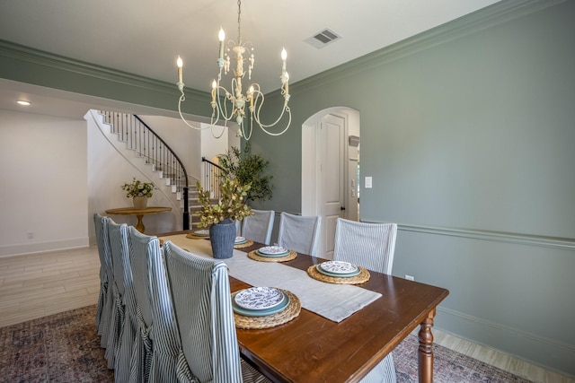 dining space featuring arched walkways, a notable chandelier, visible vents, stairs, and crown molding