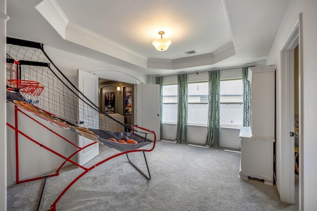 entryway with arched walkways, carpet flooring, visible vents, a tray ceiling, and crown molding