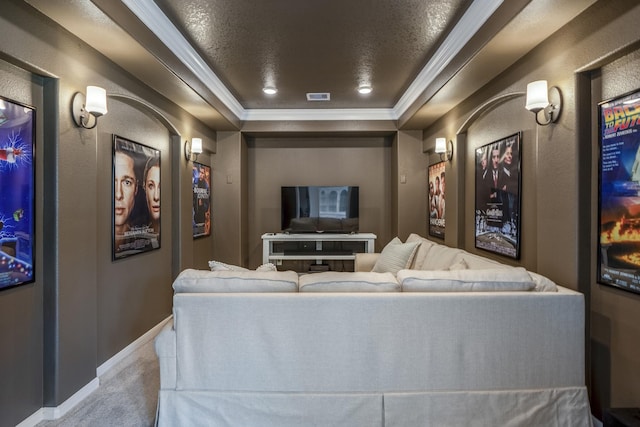 cinema room with crown molding, a raised ceiling, visible vents, carpet flooring, and baseboards