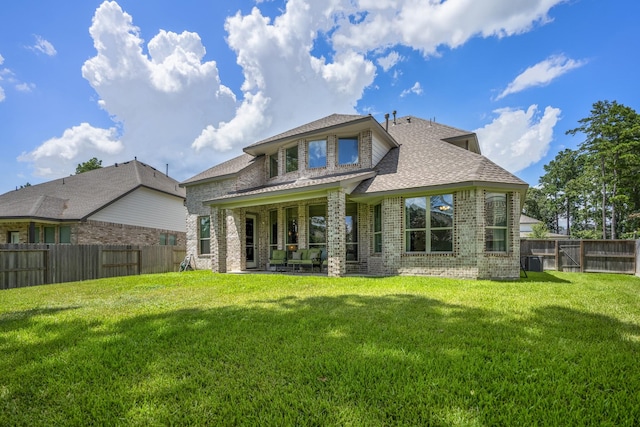 back of property featuring a fenced backyard, cooling unit, a lawn, and brick siding