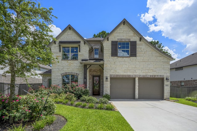 view of front facade featuring a garage, concrete driveway, stone siding, and fence