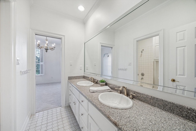 bathroom with a sink, a notable chandelier, double vanity, and crown molding