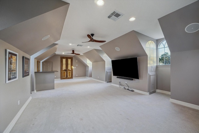 additional living space with visible vents, light carpet, a ceiling fan, baseboards, and vaulted ceiling